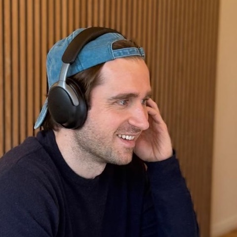 Max, who builds TaxMaxi, with headphones at his desk